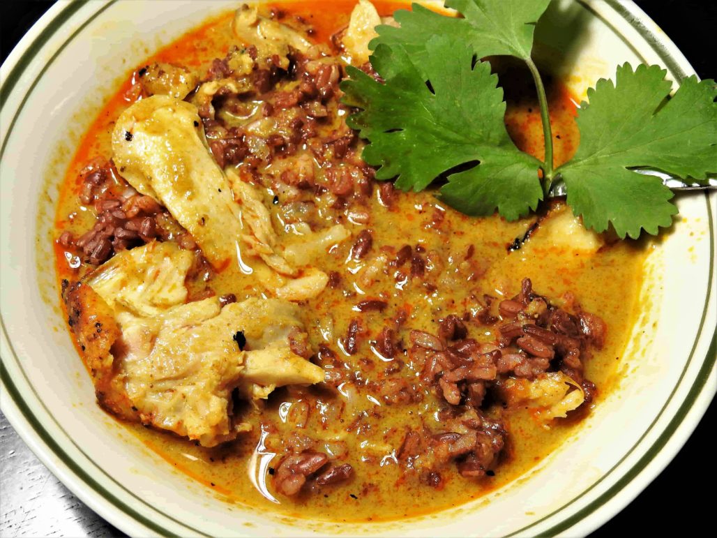 Salsa de curry sobre pollo asado y arroz rojo rubí con salsa de curry tailandesa