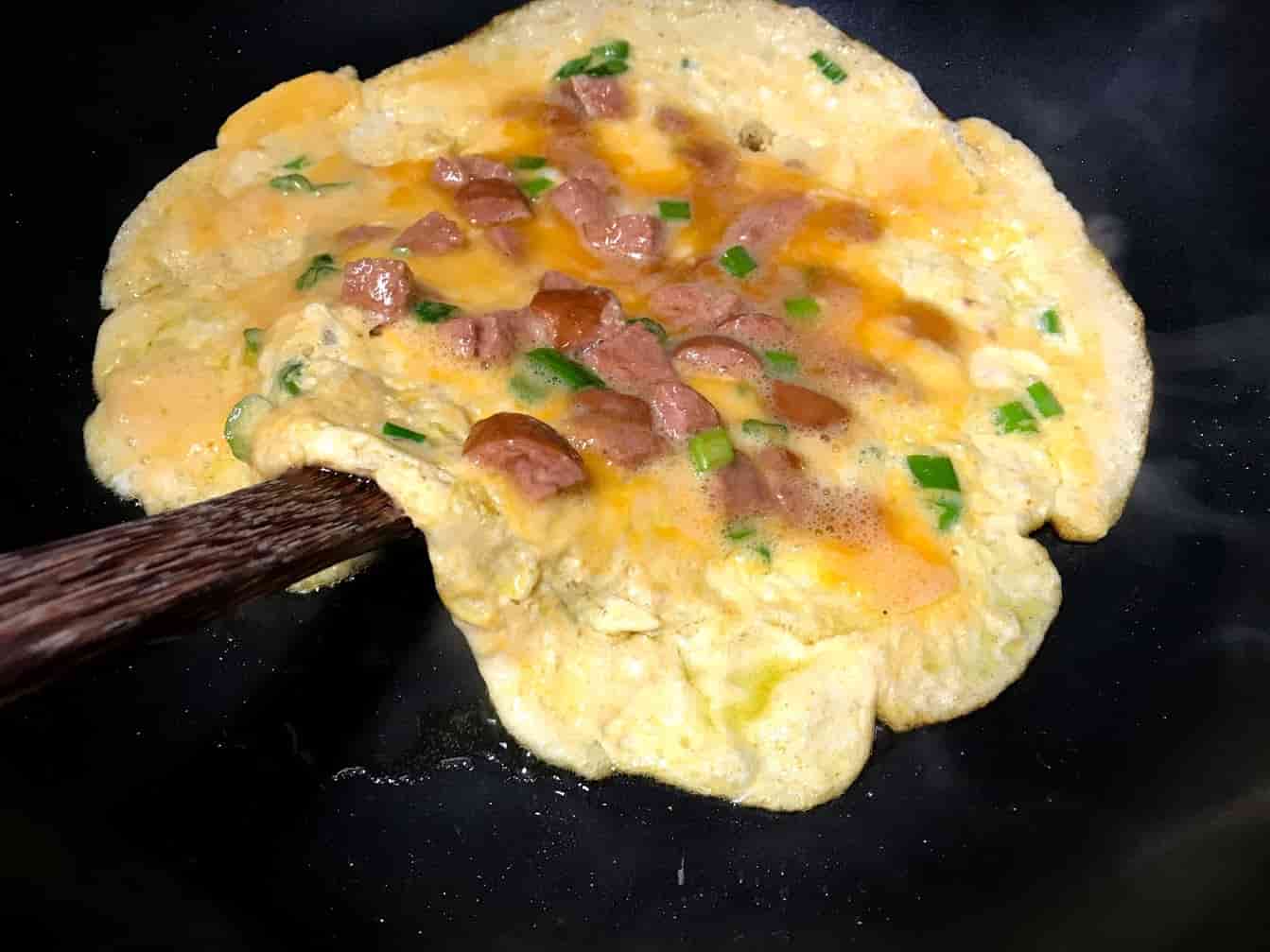 Thai Omelet with Turkey Sausage Being Flipped