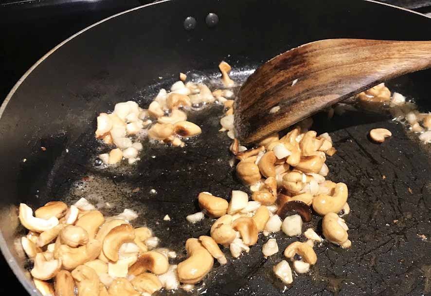 Adding garlic and cashews to Healthy Copycat Pei Wei Thai Basil Cashew Chicken Recipe